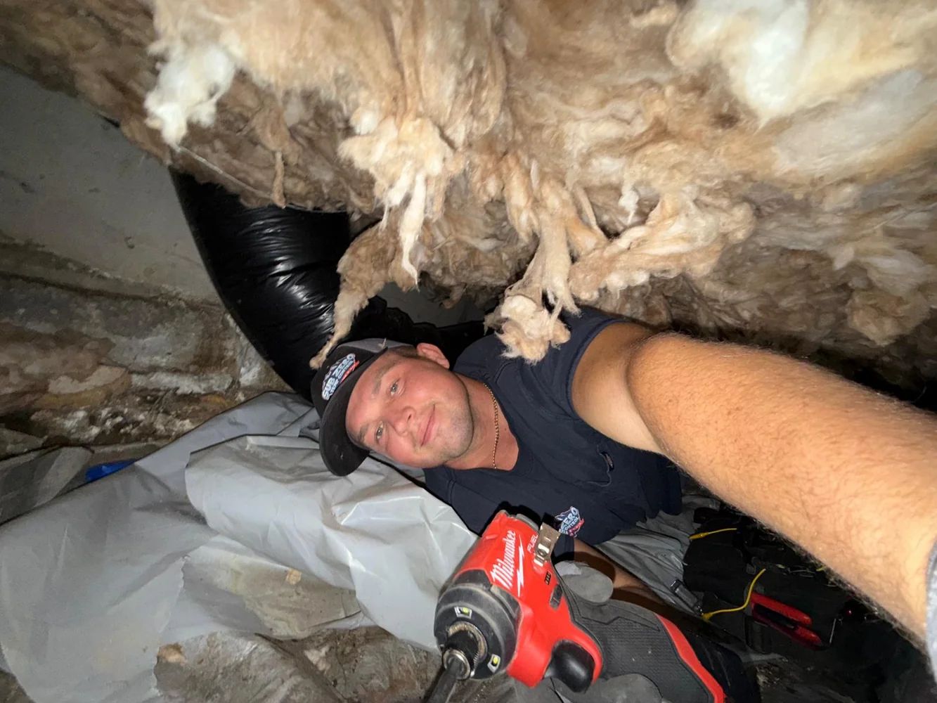 Sub Zero technician inspecting ductwork in a crawlspace